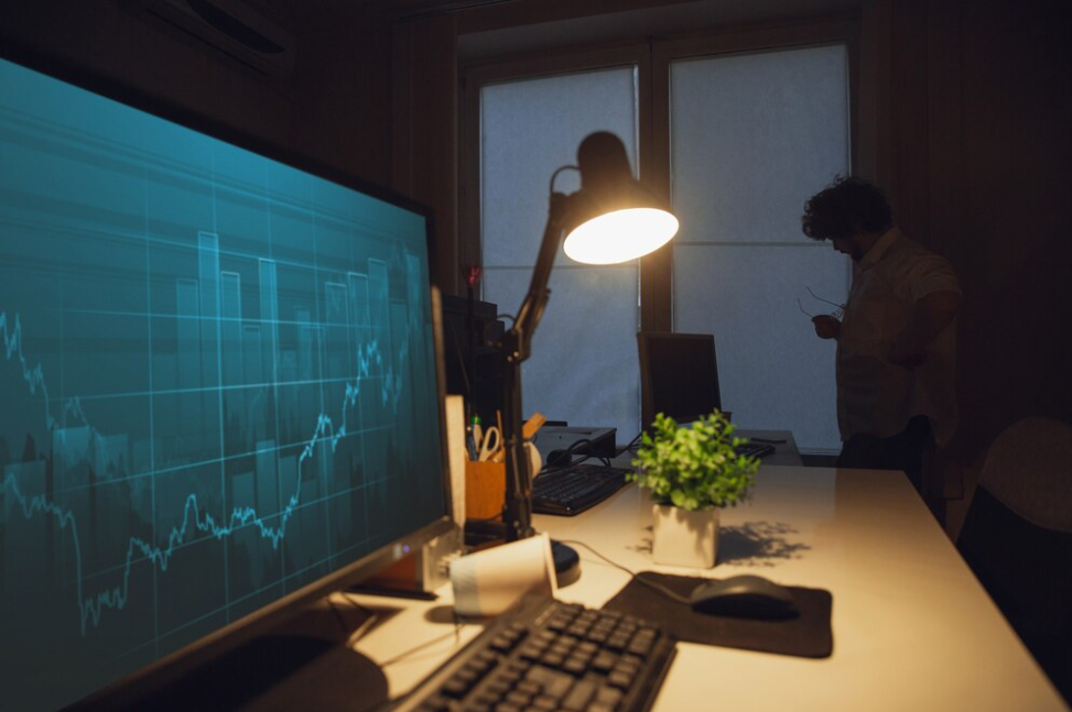 Screen with price charts and a person far from it, performing copy trading crypto.