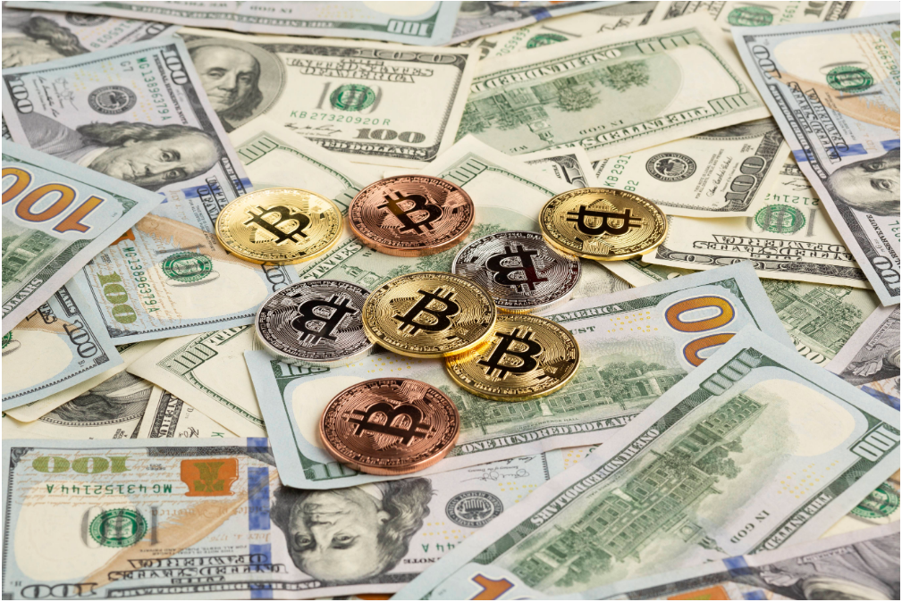 Bitcoin coins on 100-dollar bills