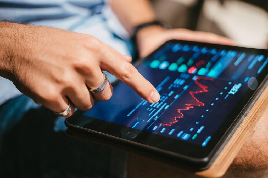Short trading is represented by a male hand that is seen checking market data on a tablet Short trading is represented by a male hand that is seen checking market data on a tablet