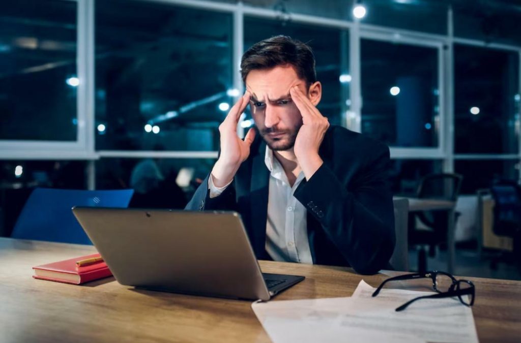 Is Binance in Trouble? Binance Voyager: photograph of a man looking at a computer with concern
