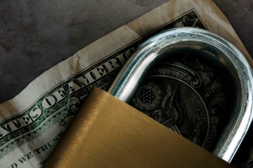 Is Binance in trouble? Is Binance banned in US?: Padlock on a dollar bill