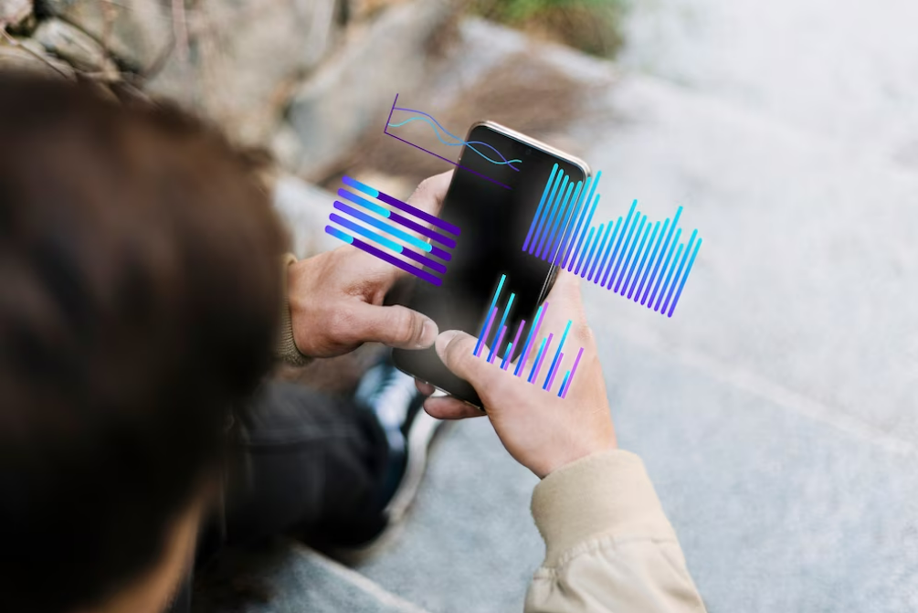 Persona utilizando un teléfono móvil con gráficas a modo de ejemplo de uso de las mejores apps para trading