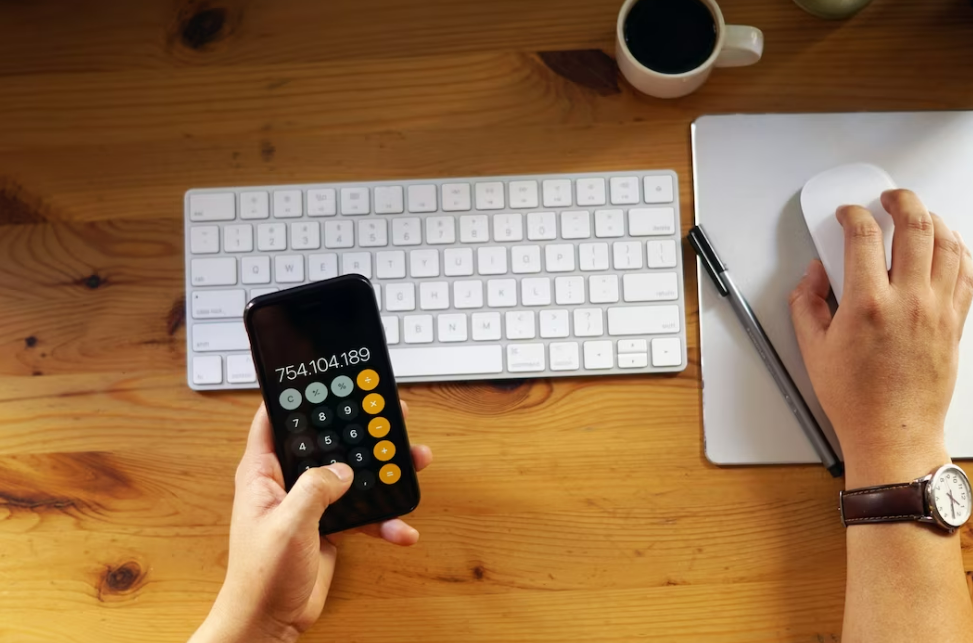 Monedas de Bitcoin y billetes de dólar sobre una mesa y una calculadora para calcular comisiones Binance