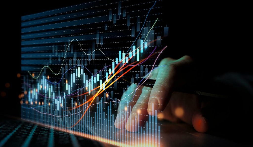 A cryptocurrency graph with the hand of a trader represents crypto futures trading strategies
