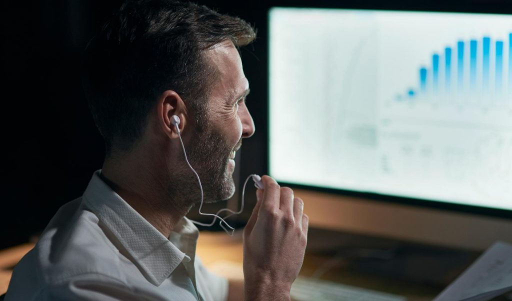 Day trading psychology: a happy man is trading in front of a PC using a trading platform