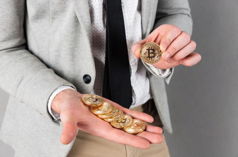 Bitcoin trading: Man with Bitcoins in his hands showing how to make money with Bitcoin for beginners